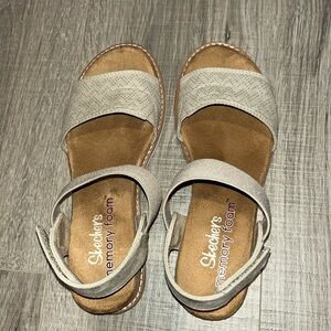 Skechers sandals in an off white to light beige color with a Velcro closure.